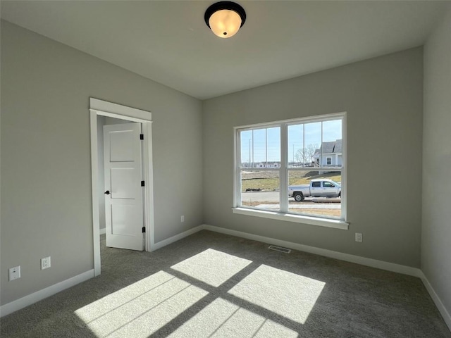 carpeted empty room featuring visible vents and baseboards