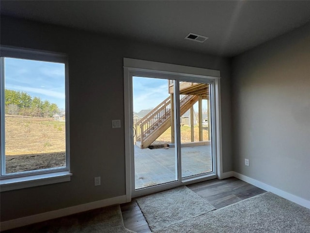 entryway featuring baseboards, visible vents, and wood finished floors