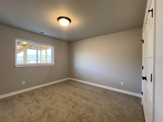 unfurnished room with visible vents, baseboards, and carpet floors