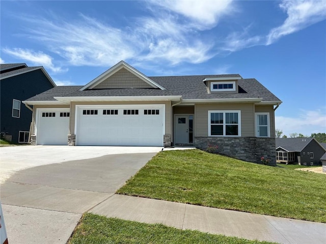 craftsman house with a front yard, a garage, a shingled roof, concrete driveway, and stone siding