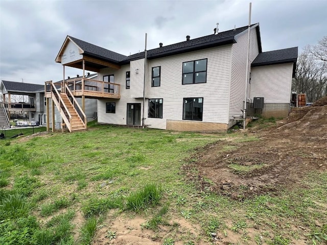 back of house featuring stairway, a wooden deck, and a yard