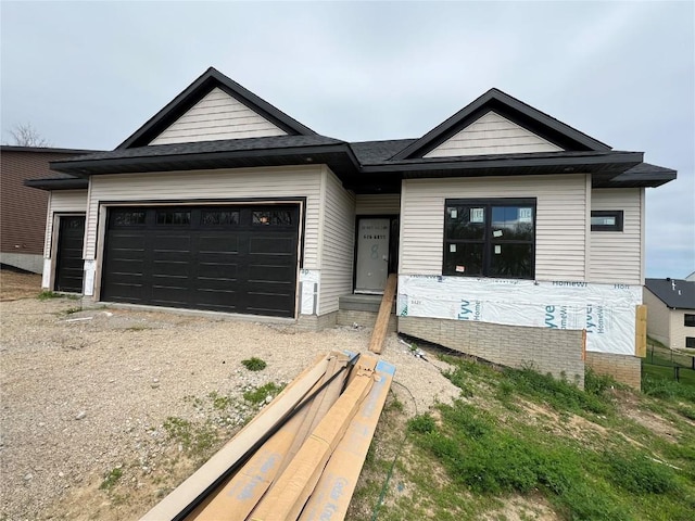 view of front facade featuring a garage and gravel driveway