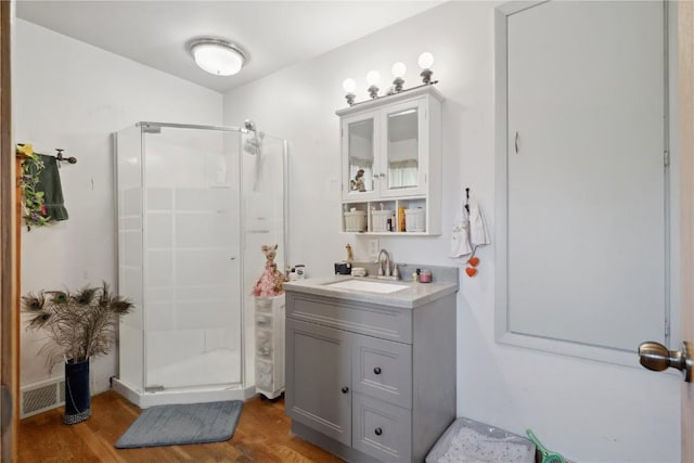 608 W 13th St, Vinton, IA 52349 - full bathroom with a shower stall, wood finished floors, and vanity