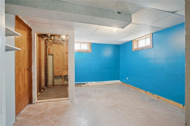 below grade area featuring baseboards and a drop ceiling