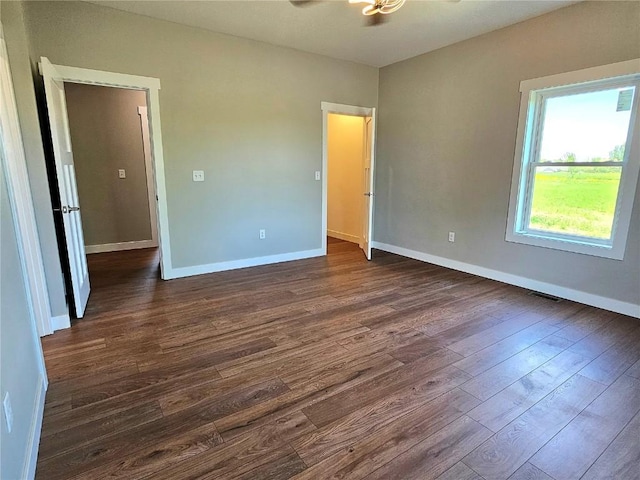 7936 217th Ave, Martelle, IA 52305 - spare room with dark wood-style floors, baseboards, and ceiling fan