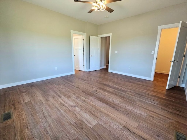 7936 217th Ave, Martelle, IA 52305 - unfurnished bedroom with wood finished floors, baseboards, and ceiling fan