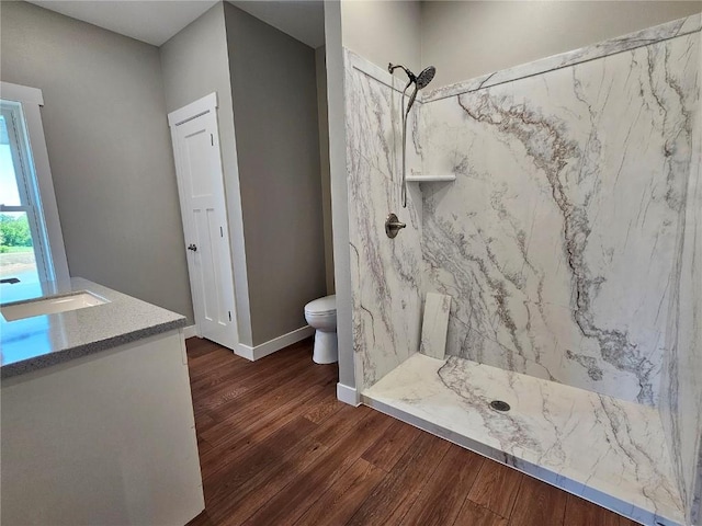 7936 217th Ave, Martelle, IA 52305 - bathroom with a marble finish shower, wood finished floors, toilet, vanity, and baseboards