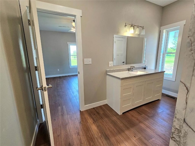 7936 217th Ave, Martelle, IA 52305 - bathroom featuring hardwood / wood-style flooring, vanity, a ceiling fan, and baseboards