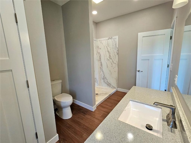 7936 217th Ave, Martelle, IA 52305 - bathroom with a shower stall, toilet, wood finished floors, baseboards, and vanity