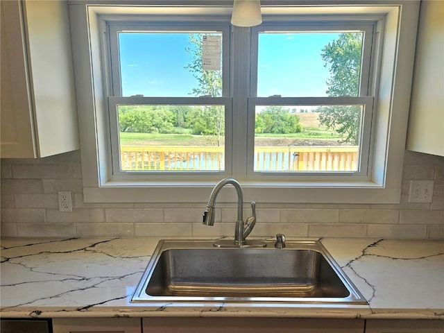 7936 217th Ave, Martelle, IA 52305 - kitchen with a sink, backsplash, white cabinetry, and light stone countertops