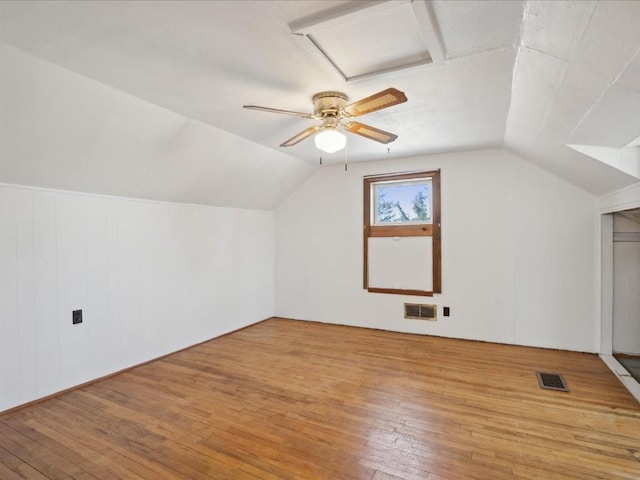 bonus room with visible vents, light wood-style flooring, and vaulted ceiling