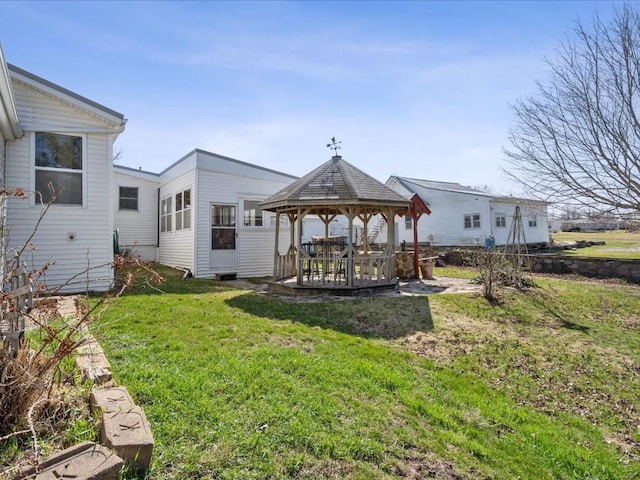 rear view of property featuring a gazebo and a lawn