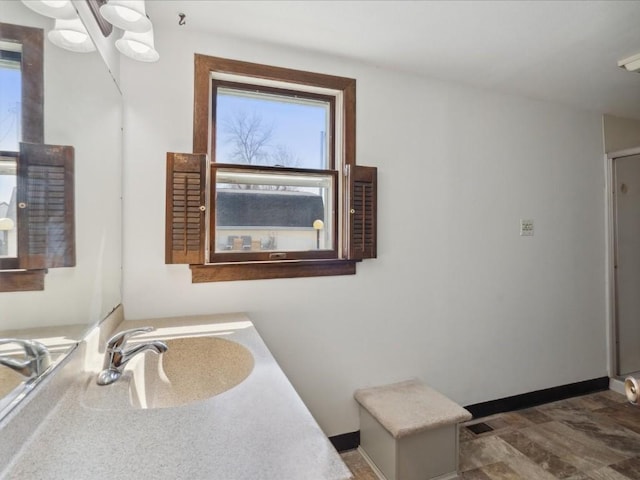 bathroom featuring baseboards and a sink