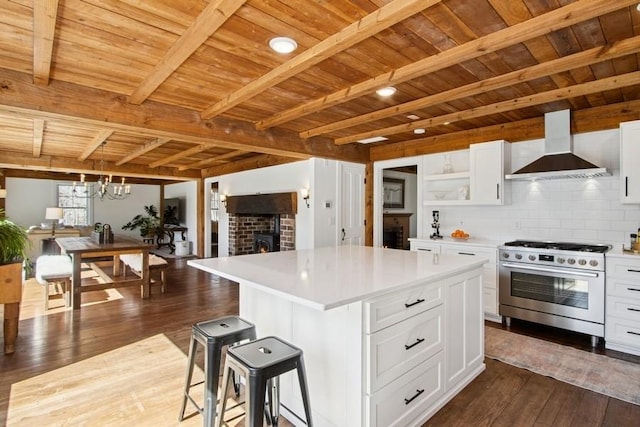 kitchen with open shelves, wooden ceiling, stainless steel stove, dark wood-style floors, and wall chimney range hood