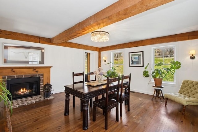 dining room featuring beam ceiling, plenty of natural light, a notable chandelier, and dark wood finished floors
