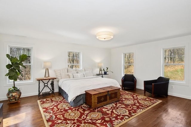 bedroom featuring baseboards, wood finished floors, and multiple windows