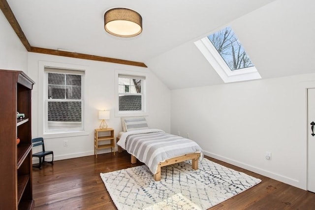 bedroom featuring lofted ceiling with skylight, dark wood-type flooring, and baseboards