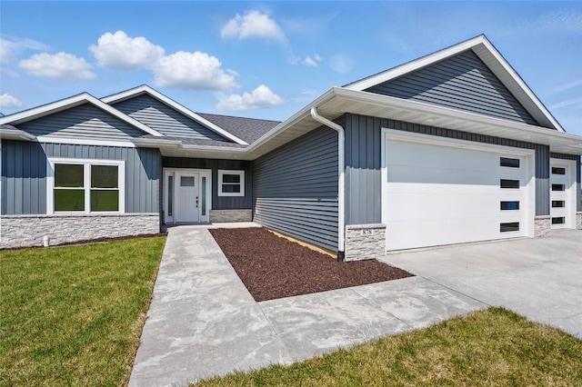 878 Silver Ln, Iowa City, IA 52245 - ranch-style home with stone siding, a garage, board and batten siding, concrete driveway, and a front yard