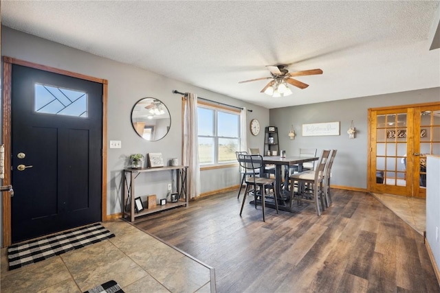 1305 W 4th St, Vinton, IA 52349 - dining space with a ceiling fan, a textured ceiling, baseboards, and wood finished floors