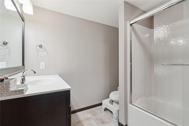 621 Doe Ave, Tiffin, IA 52340 - bathroom featuring baseboards, vanity, combined bath / shower with glass door, and toilet