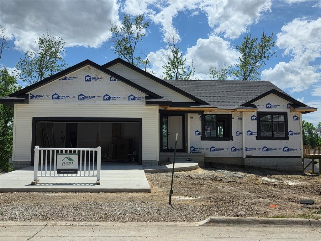 property in mid-construction with an attached garage and roof with shingles