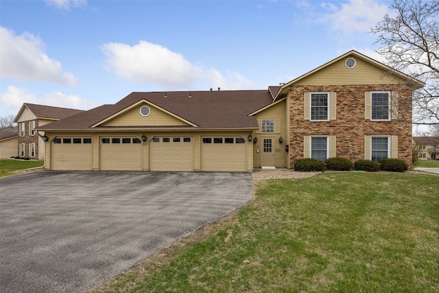 view of front facade with driveway, an attached garage, brick siding, and a front yard