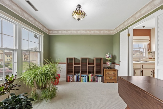 interior space featuring visible vents, crown molding, and carpet flooring