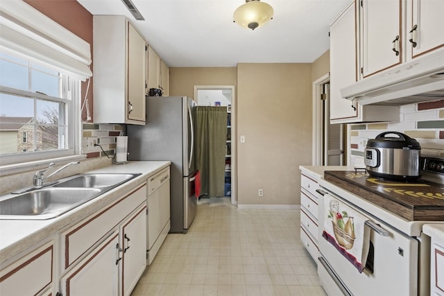 kitchen with white appliances, under cabinet range hood, backsplash, a sink, and visible vents