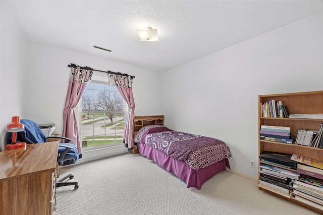 bedroom with visible vents, carpet, and a textured ceiling