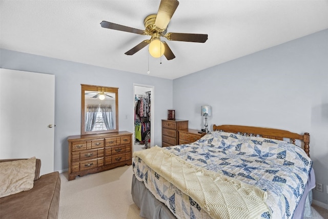 bedroom featuring a spacious closet, a ceiling fan, light carpet, and a closet