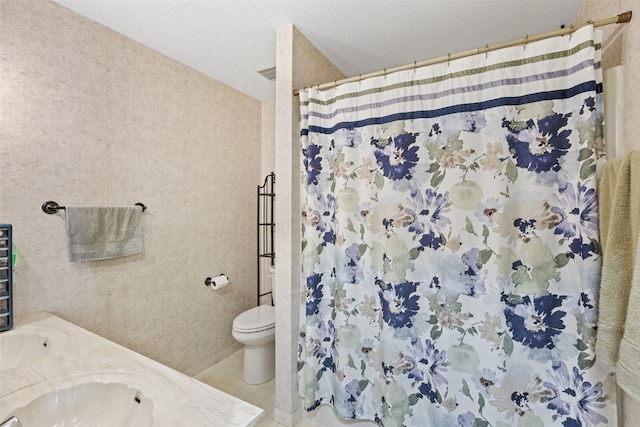 full bath with toilet, curtained shower, a sink, a textured ceiling, and tile patterned flooring