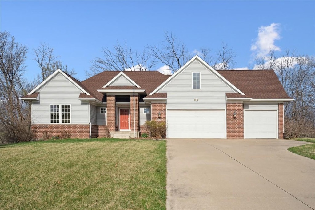 503 Wanatee Creek Cir, Marion, IA 52302 - view of front facade with driveway, brick siding, a shingled roof, and a front yard