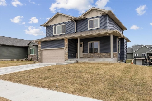 craftsman house with stone siding, a front yard, driveway, and an attached garage