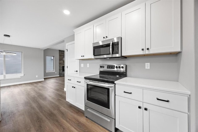 kitchen with dark wood-type flooring, light countertops, stainless steel appliances, and white cabinets