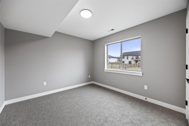 carpeted spare room featuring baseboards and visible vents