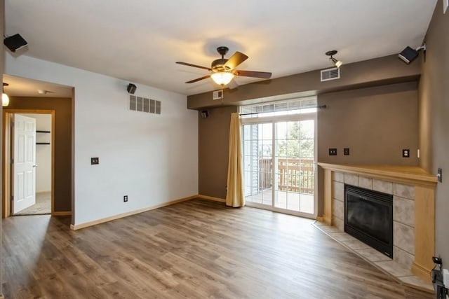 unfurnished living room featuring baseboards, ceiling fan, visible vents, and a tiled fireplace