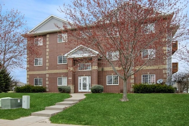 view of front of house with a front yard and brick siding