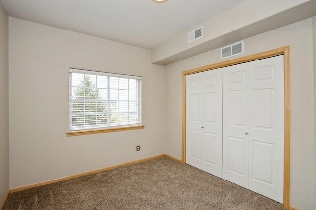 unfurnished bedroom featuring baseboards, visible vents, a closet, and carpet flooring