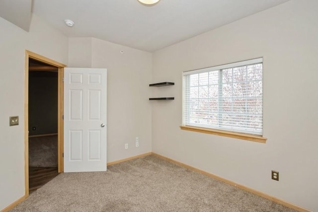 spare room featuring carpet and baseboards