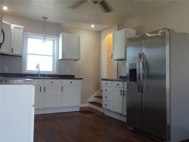 549 Marengo Ave, Marengo, IA 52301 - kitchen featuring stainless steel fridge, a ceiling fan, white cabinetry, dark wood-type flooring, and pendant lighting