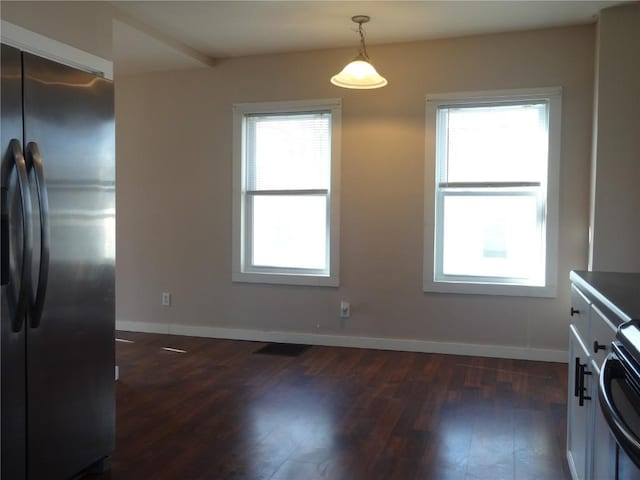 549 Marengo Ave, Marengo, IA 52301 - dining room featuring dark wood-type flooring, baseboards, visible vents, and a wealth of natural light