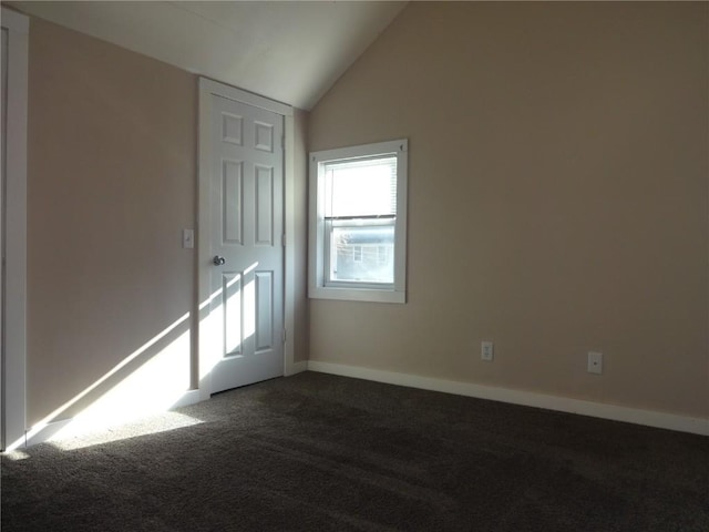 549 Marengo Ave, Marengo, IA 52301 - unfurnished room featuring baseboards, dark colored carpet, and vaulted ceiling