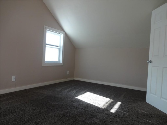 549 Marengo Ave, Marengo, IA 52301 - additional living space with dark carpet, baseboards, and vaulted ceiling