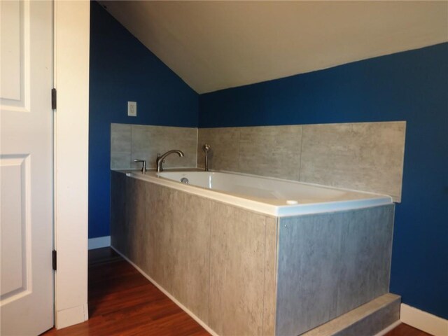 549 Marengo Ave, Marengo, IA 52301 - full bath with a bath, vaulted ceiling, wood finished floors, and baseboards