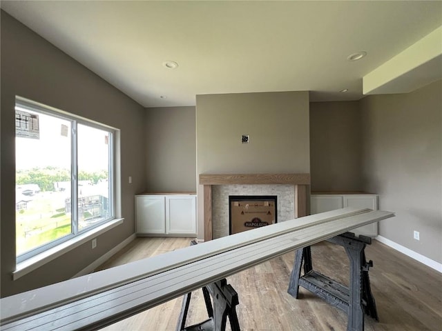 1306 E Gable Way, Tiffin, IA 52340 - unfurnished living room featuring a fireplace, baseboards, wood finished floors, and recessed lighting