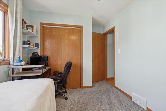 carpeted office space with baseboards and visible vents