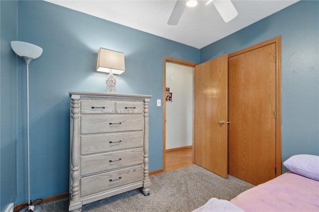bedroom with a closet, carpet flooring, baseboards, and a ceiling fan