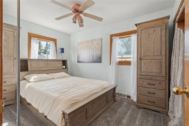 carpeted bedroom with visible vents and ceiling fan