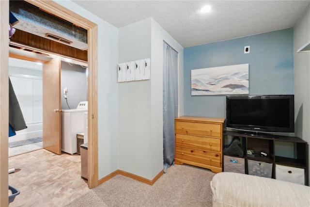 bedroom featuring washer / clothes dryer, baseboards, a textured ceiling, carpet floors, and visible vents