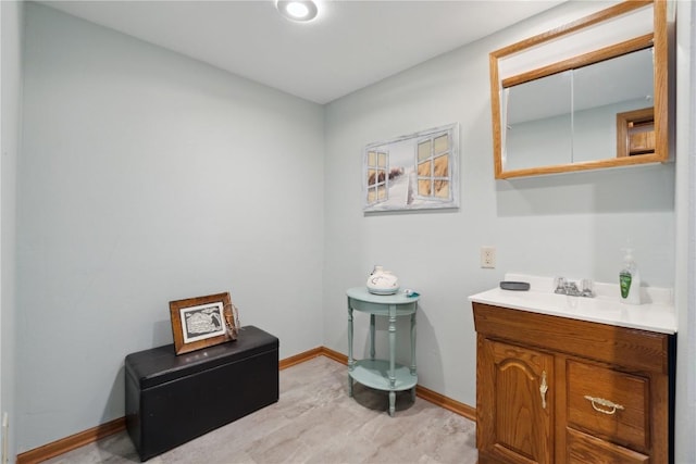 bathroom featuring vanity, baseboards, and wood finished floors